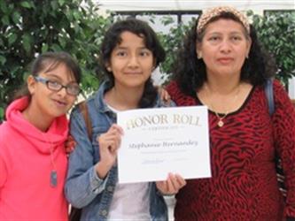 Parent with two children holding Honor Roll Certificate