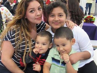 Mother poses with her honor roll daughter and her two younger siblings.