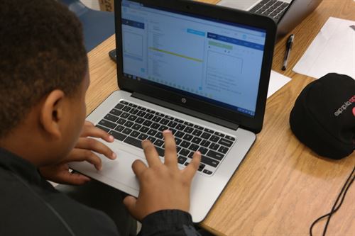 Boy typing on a laptop.