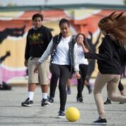 Students kicking around a ball.