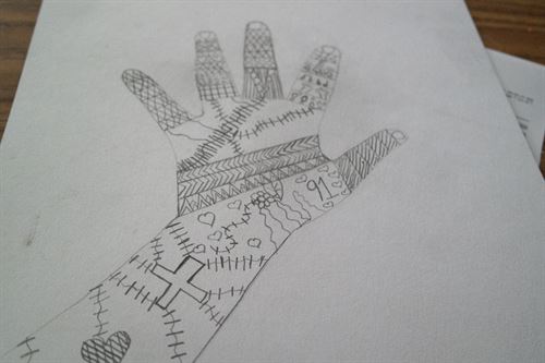 Drawing of a hand decorated with various patterns and shapes.