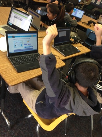 A student raising his hand in computer lab